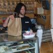 Cafe employee preparing to give a take out order to a customer.